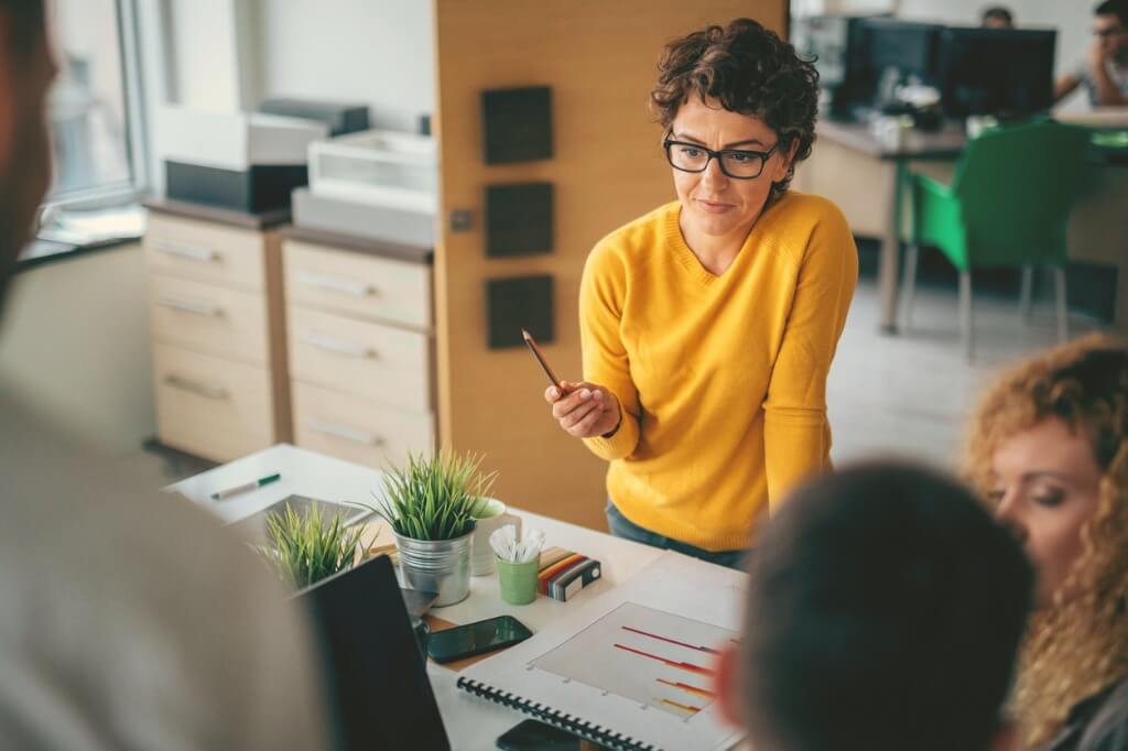 Woman presenting to group of team members.